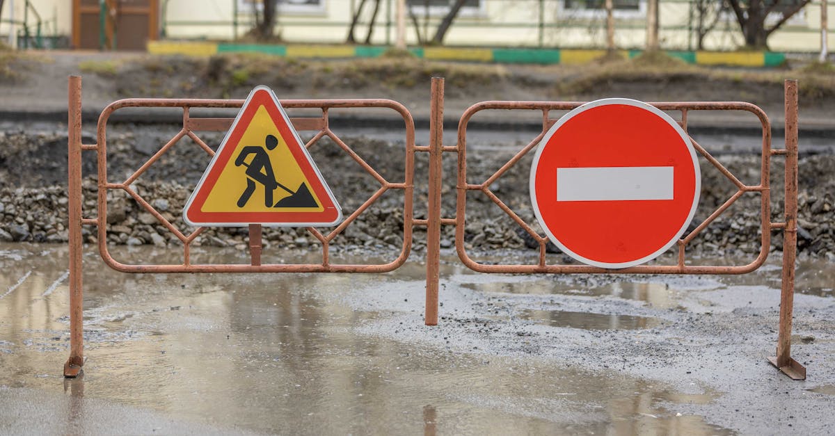close up of construction signs and barriers in a muddy area outdoors indicating no entry